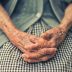 äldre persons händer i knät