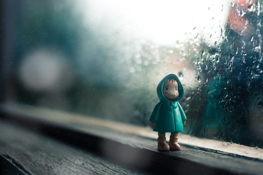 leksaksfigur framför fönster som det regnar på