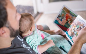 man läser bok för bebis