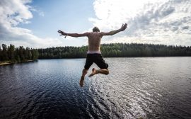 Kille hoppar i en sjö